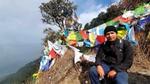 Govinda Shahi in a mountain setting with Nepalese prayer flags