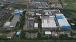 An aerial view of Unilever's Gandhidham factory in India,. Blue, grey and white rooftops surrounded by green fields.