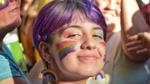 A girl smiling with a rainbow on her face