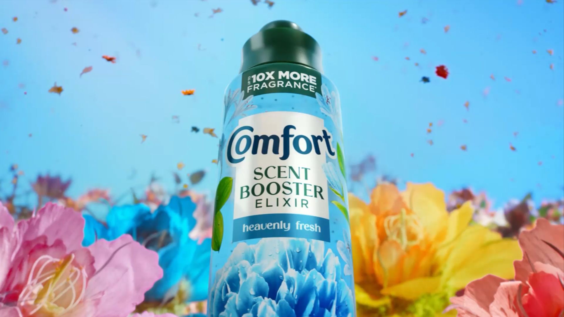 A bottle of Comfort Scent Booster Elixir surrounded by flowers and petals.