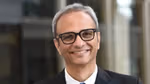 Profile picture of Srinivas Phatak wearing a white shirt, dark tie and suit jacket. He is wearing glasses.