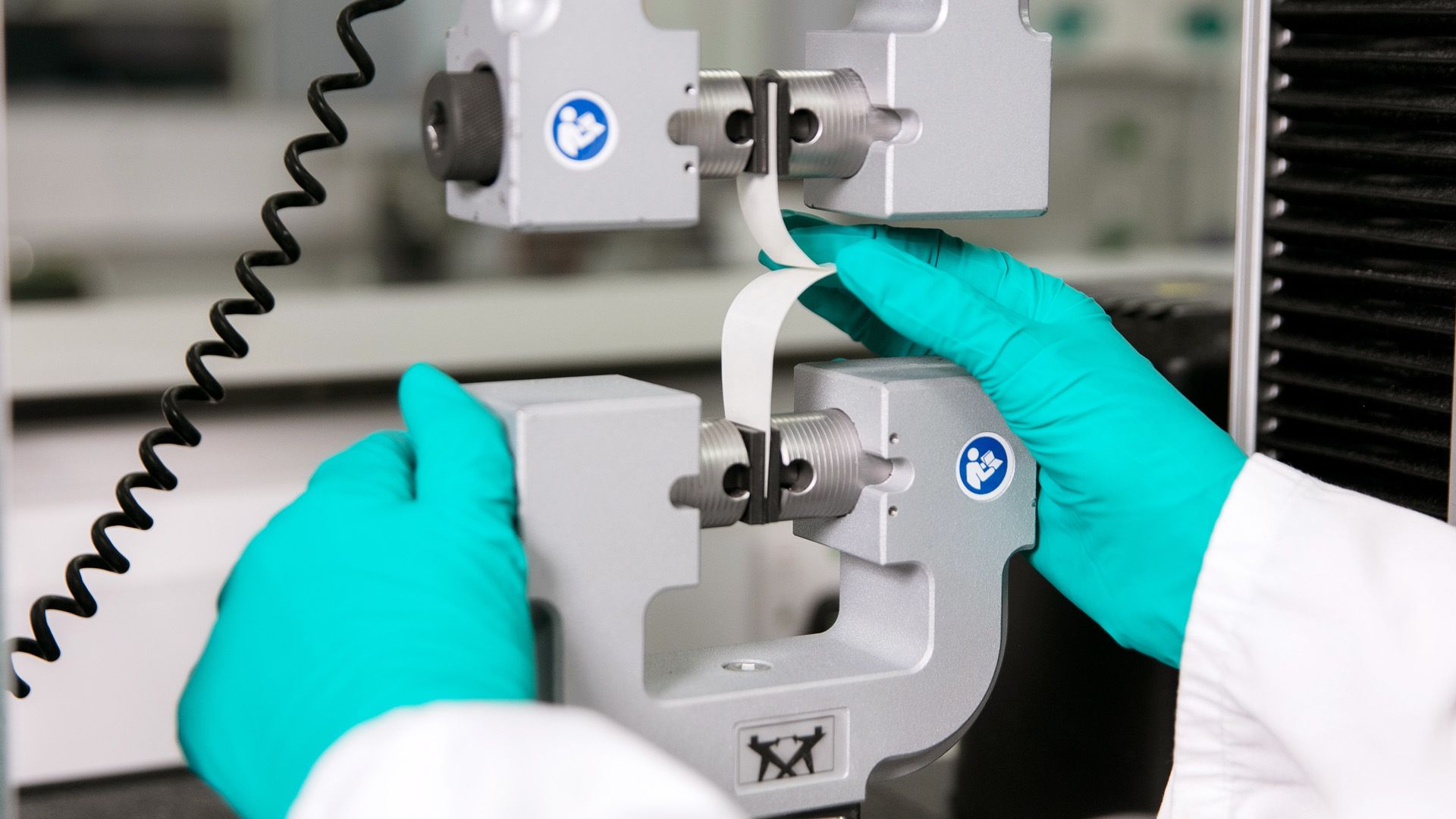 Unilever materials scientist testing paper packaging using a laboratory machine.