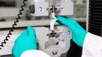 Unilever materials scientist testing paper packaging using a laboratory machine.
