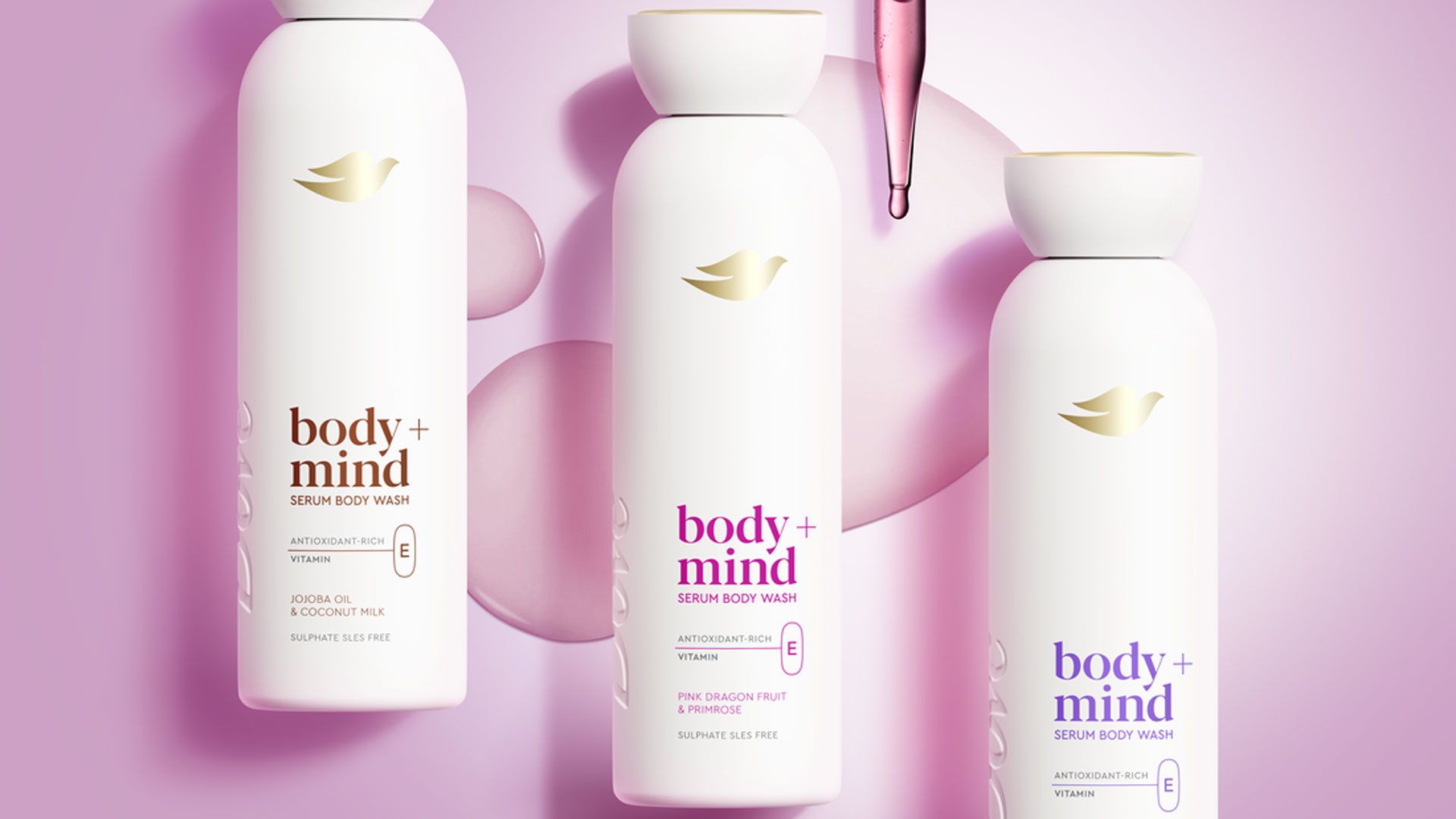 Three Dove Body+Mind serum body wash bottles displayed on a pink background with liquid droplets.