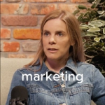 Woman in a denim jacket speaking into a microphone, with the word “marketing” overlaid.