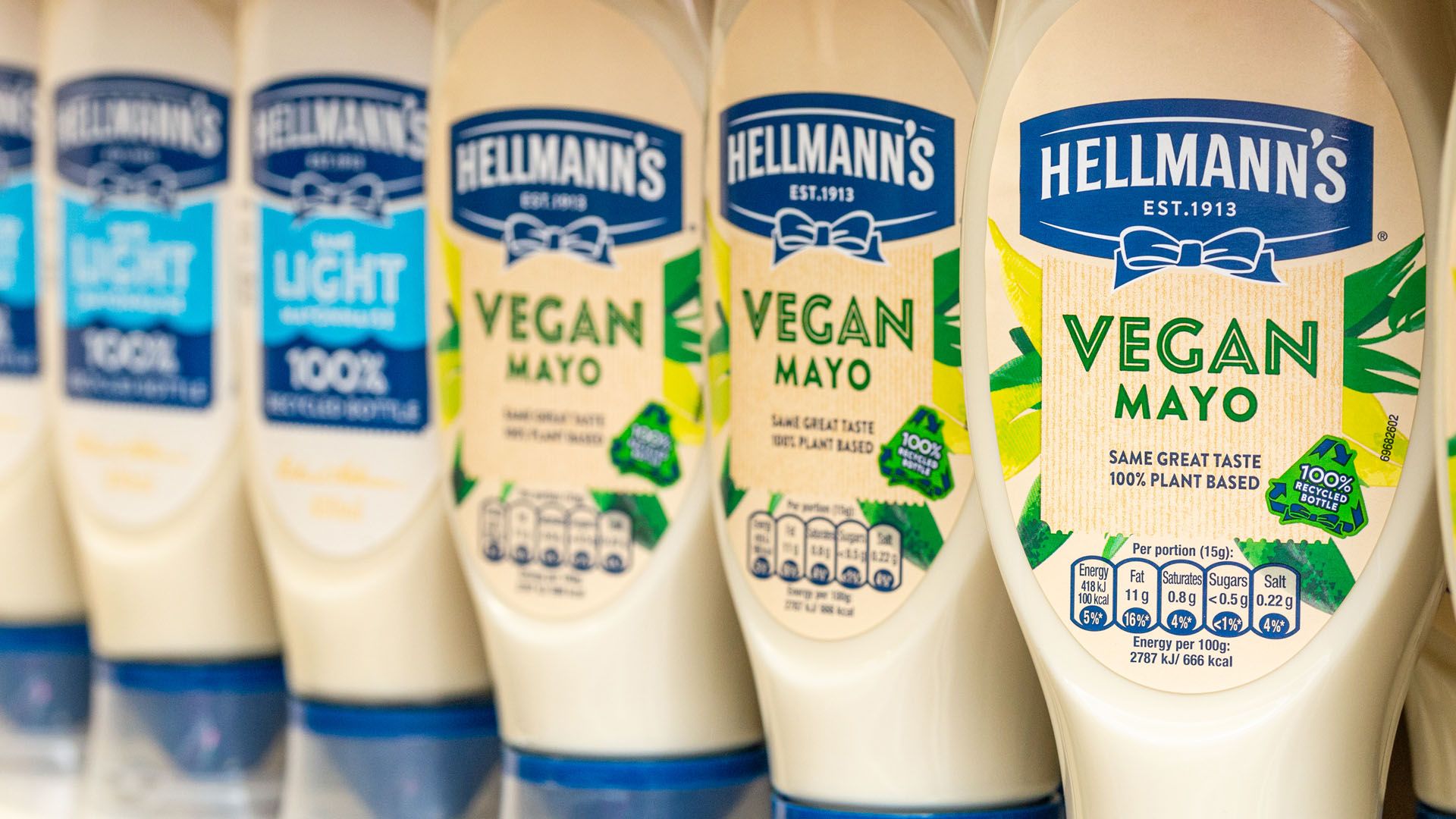 Line-up of Hellmann’s Vegan Mayo and Hellmann’s Light Mayo packs on a supermarket shelf.