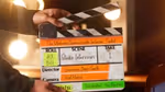 Hands operating a clapperboard