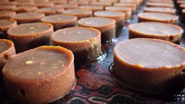 Round blocks of coconut sugar laid out on a table with a patterned covering.
