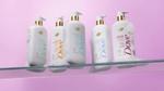 Five products from the Dove MicroMoisture-enriched body wash range. The bottles are white with gold accents and colourful branding, shot against a lilac background.