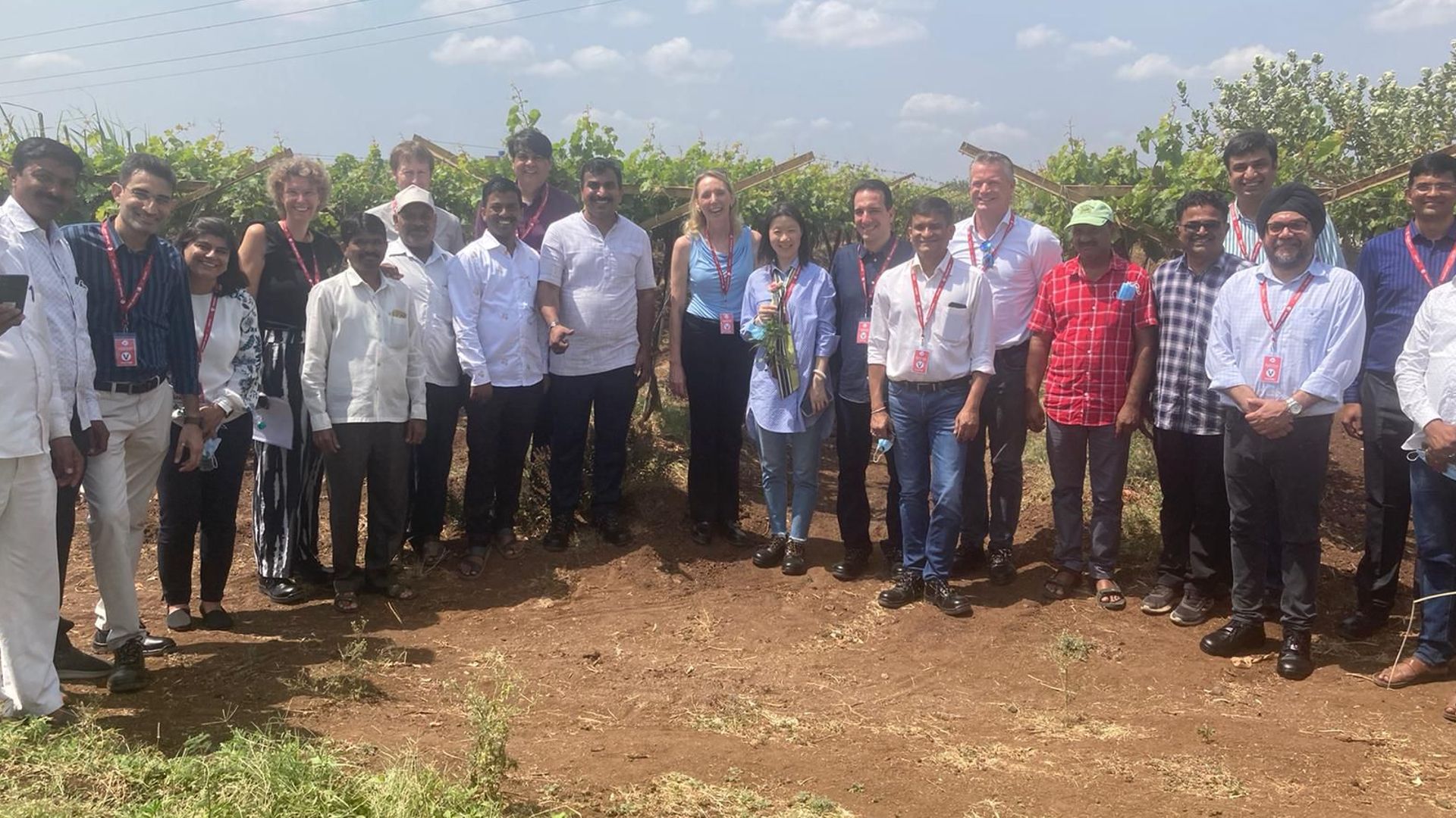 Image of Hanneke in a semi circle of people in a field as per original