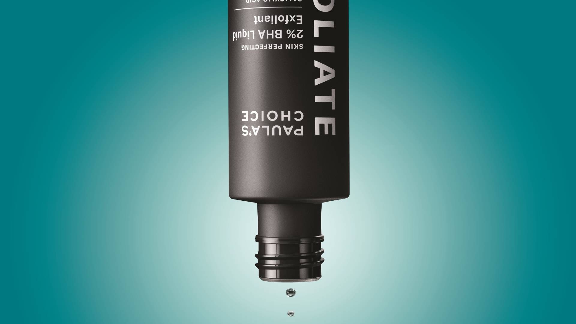 Black bottle of skincare product with drops against blue background.