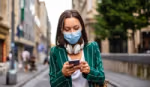 Woman walking in the city and checking her smartphone