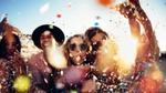 Teenage friends partying and blowing colourful confetti from their hands