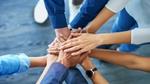 Group of hands stacked together symbolizing teamwork