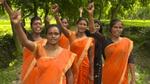 Photo of six women with arms raised in the air
