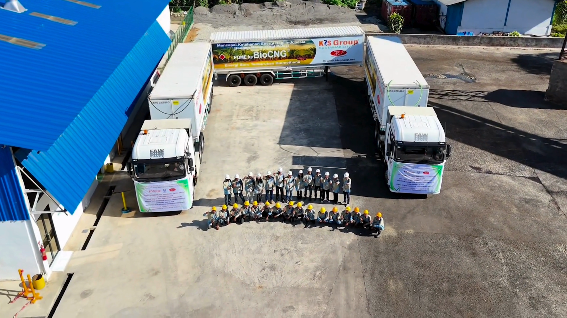 Aerial view of workers and biomethane trucks outside a palm oil facility in Indonesia.