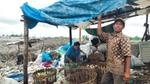 Two waste workers sorting through plastic