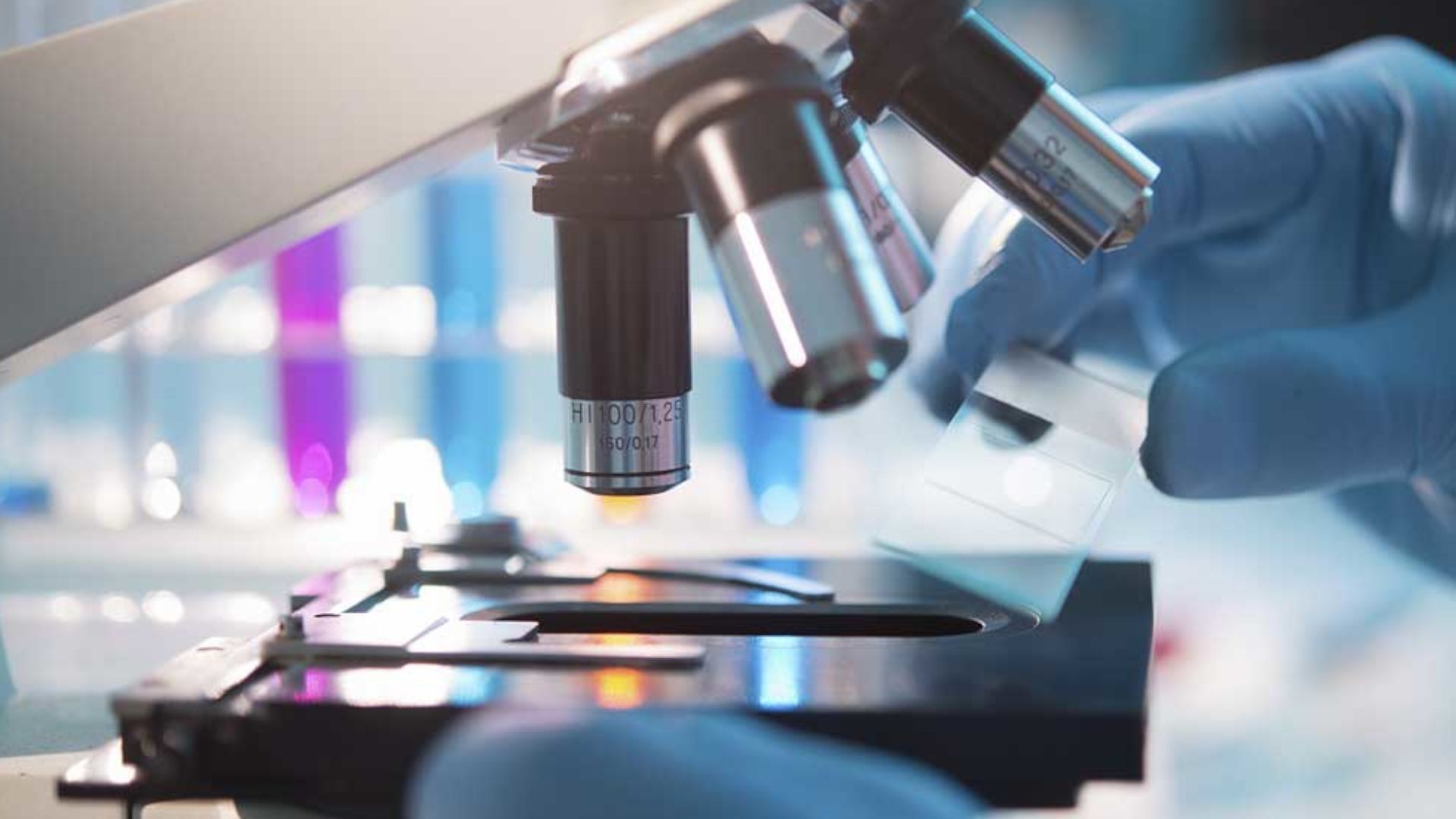 A scientist placing a slide under a microscope