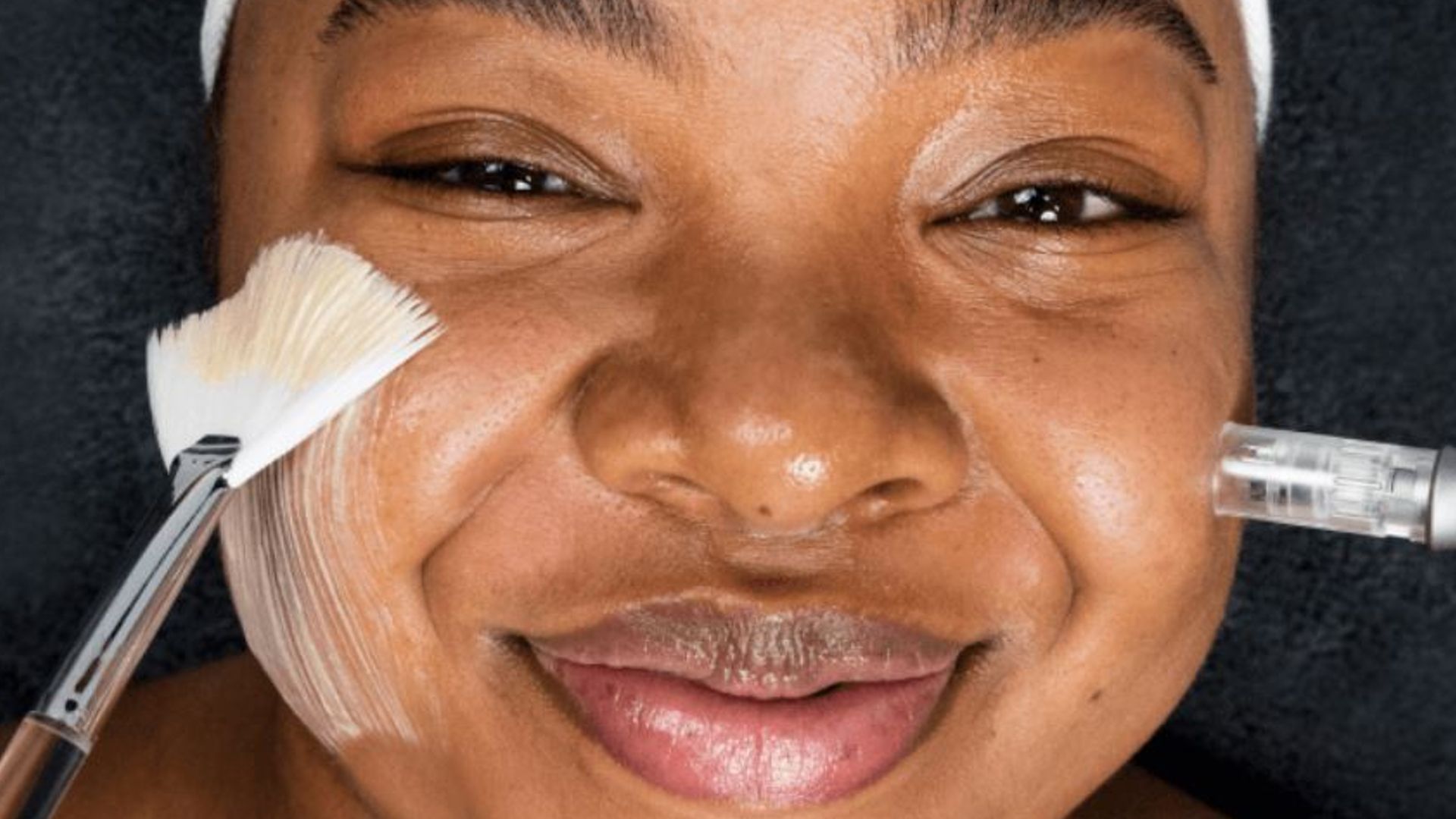 Young woman with melanin-rich skin undergoing a beauty treatment from a Dermalogica skincare professional 