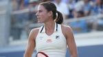 Tennis player Emma Navarro competes wearing a white outfit with a Dove logo on her right shoulder