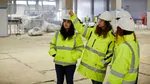 A group of employees in hi-vis jackets and hard hats