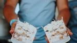Tub of Ben & Jerry’s Sundae sliced in half, showing the indulgent layers and whipped ice cream topping