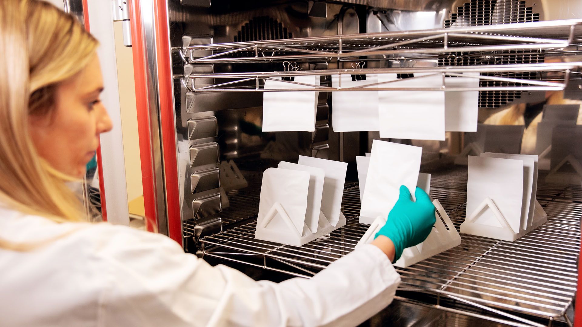 Female Unilever materials scientist examining paper packaging samples in an R&D lab