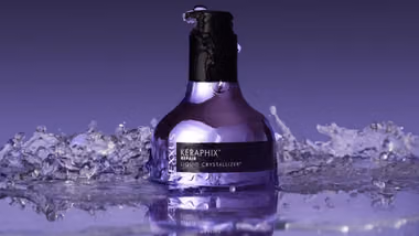 A bottle of Nexxus Keraphix Liquid Crystallizer. The bottle is a metallic silver-lilac colour with a black pump.