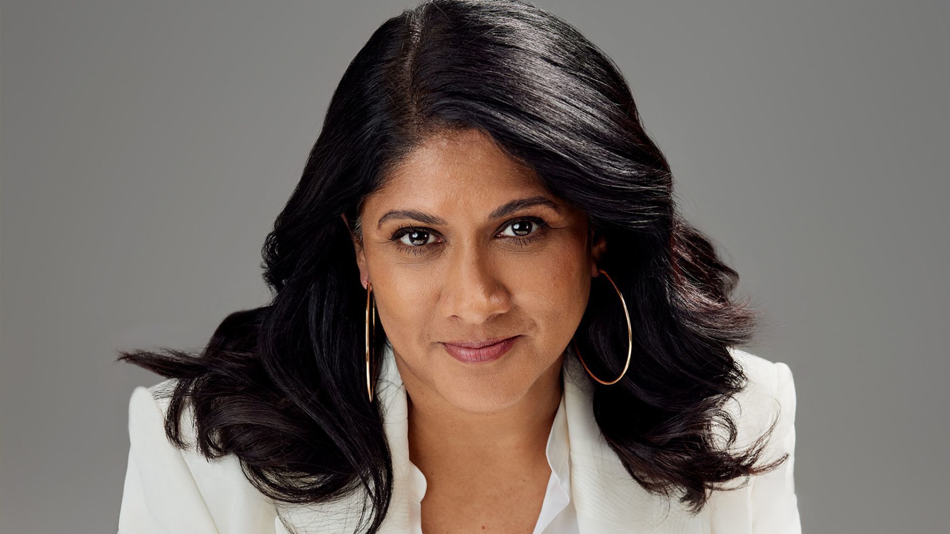 Priya Nair, CEO & Managing Director, Hindustan Unilever Limited. She has long dark wavy hair, is wearing a white suit and large hooped earrings.