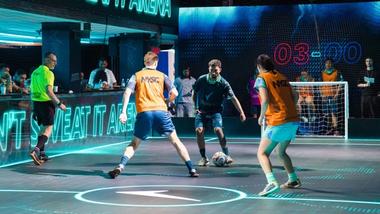 Men play on an LED football pitch at Unilever's House of Fresh. A Rexona logo is illuminated on the floor.