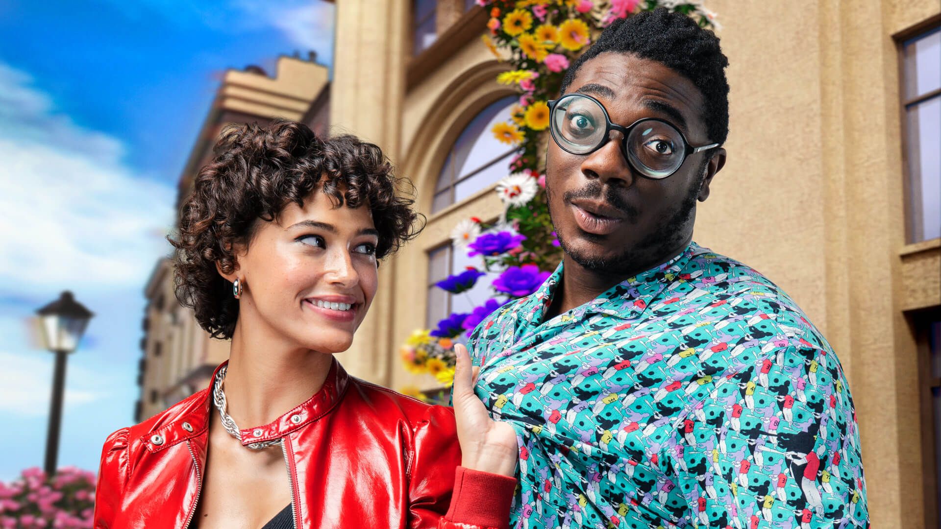 A woman in a red jacket smiling whilst flirtatiously looking at a man in a light blue pattern shirt. She is also pulling him by his shirt.