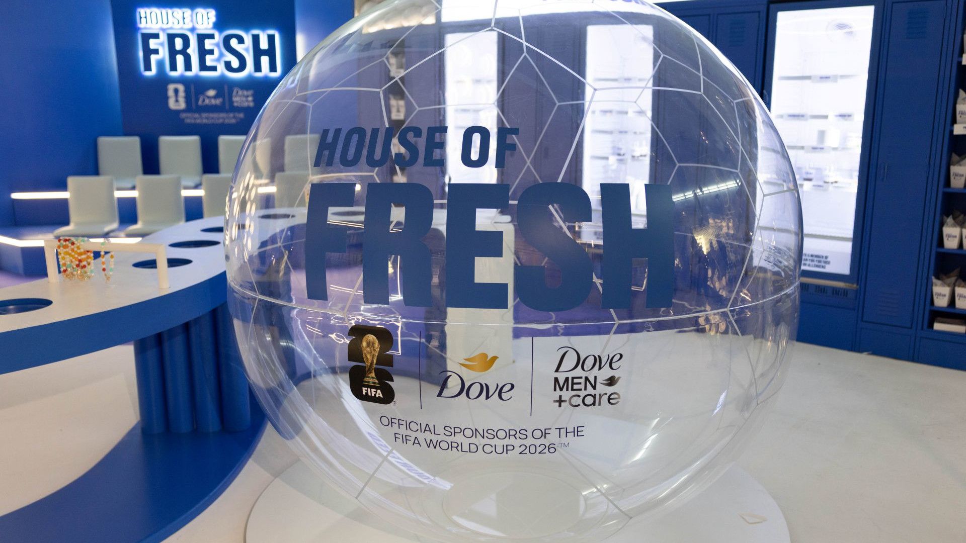 Inside Unilever’s House of Fresh event, blue walls, white floor. A clear ball displays logos for Dove and Dove Men+Care.