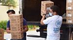 Photo of two men taking and carrying boxes from the back of a truck