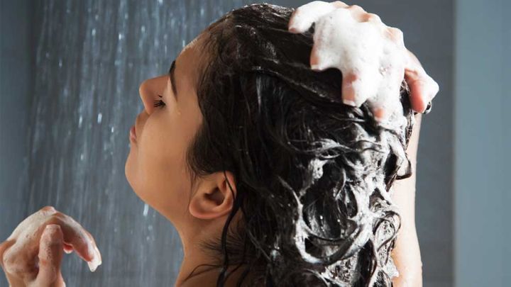Woman shampooing hair in shower