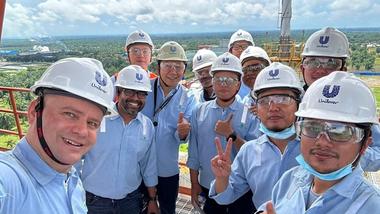Chief Procurement Officer Willem Uijen with a team of people wearing hard hats, on a high-rise platform at a factory.
