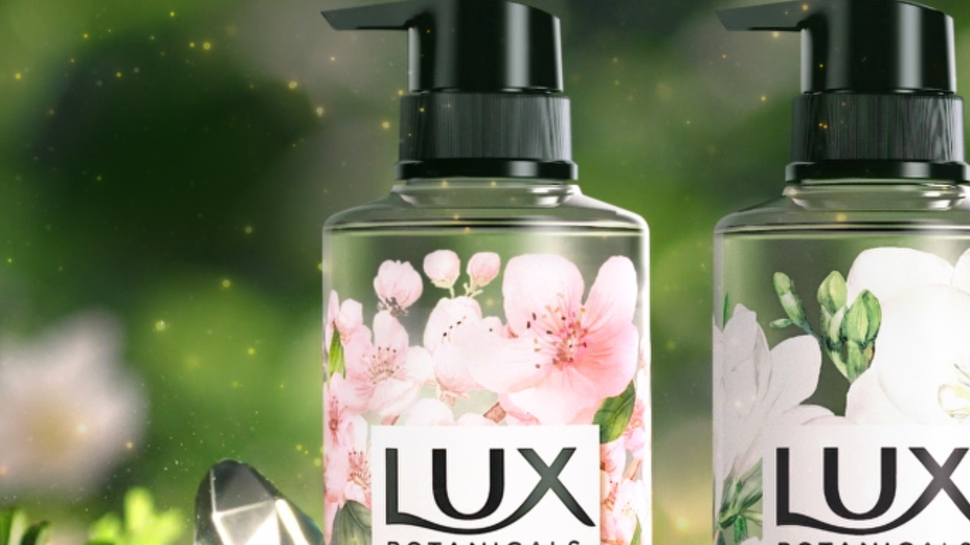 A close‑up of a LUX Botanicals liquid soap bottle with a black pump lid, decorated with pink cherry blossom illustrations. 