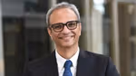 Profile picture of Srinivas Phatak wearing a white shirt, dark tie and suit jacket. He is wearing glasses.