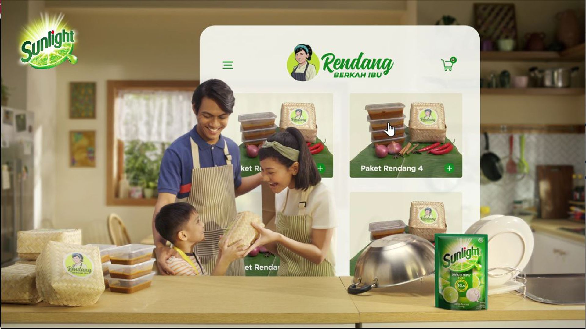 A woman stands proudly behind a table of food with her family with a banner above her and people applauding