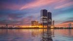 Karachi, Pakistan. In the foreground, the sea reflects the sunset and the base of the Bahria Tower glows with light.