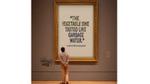 Image of a man standing in front of a large poster with a comment about ‘Lost the Pot’ Noodles saying, ‘The vegetable one tasted like garbage water’