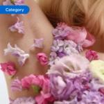 Close-up of an arm adorned with pink and purple flower petals, creating a floral decorative effect.