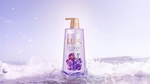 A purple bottle of Lux Sparkling shower gel with a breaking wave in the background.