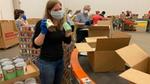 Woman packing items for United for America, an initiative designed to support communities in need during Covid-19.