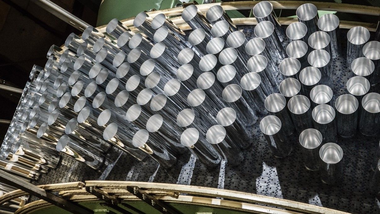 Multiple aluminium cans on a production line.