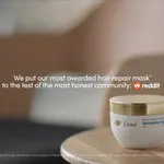 A jar of Dove Intensive Repair hair mask sits on a wooden surface in a softly lit, minimalist room with a neutral-toned chair in the background. White text on the image reads: “We put our most awarded hair repair mask to the test of the most honest community: Reddit,” with the Reddit logo displayed next to the text. A small Dove logo appears in the top left corner.