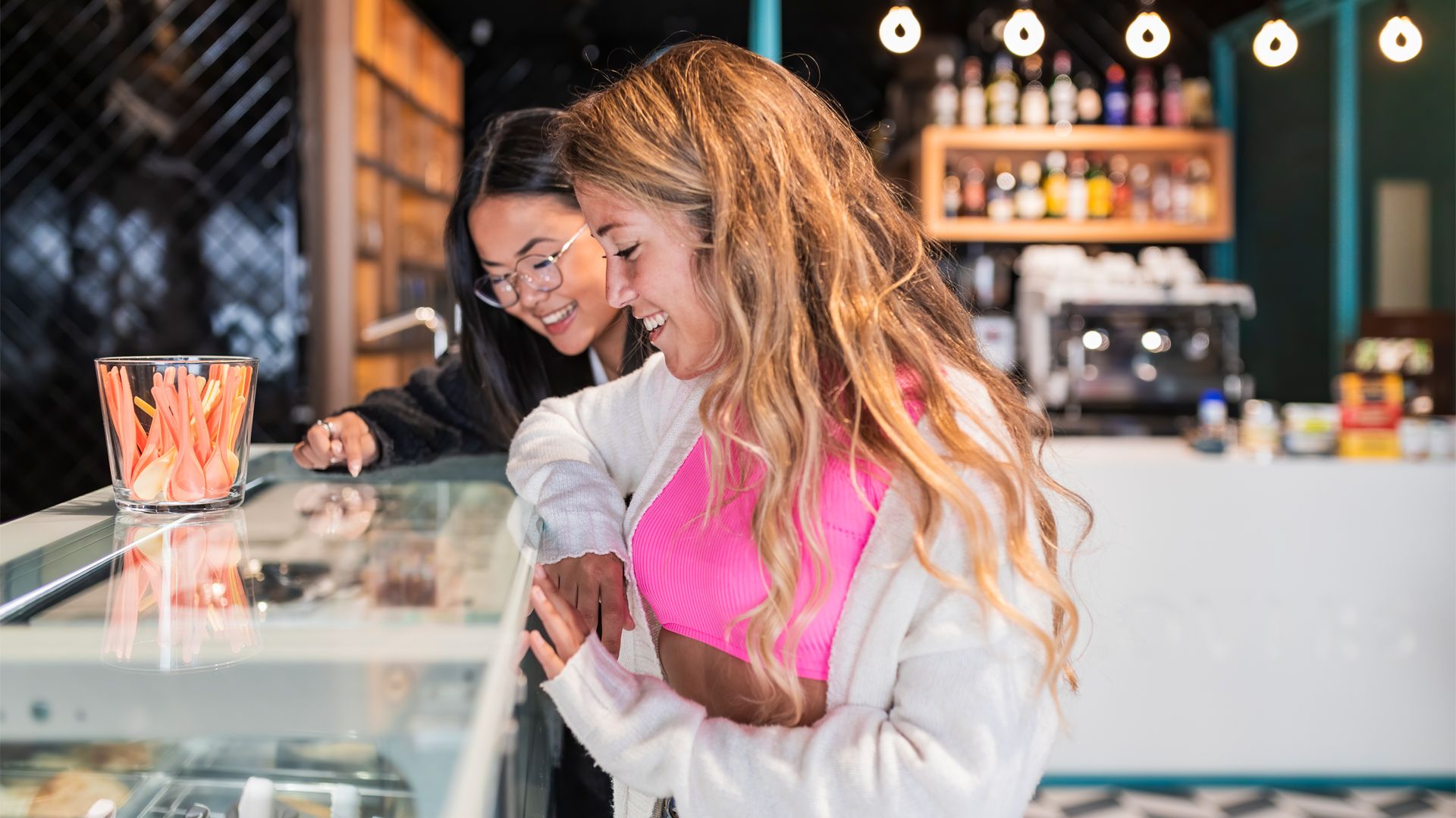 Two friends choosing an ice cream from a retail ice cream cabinet