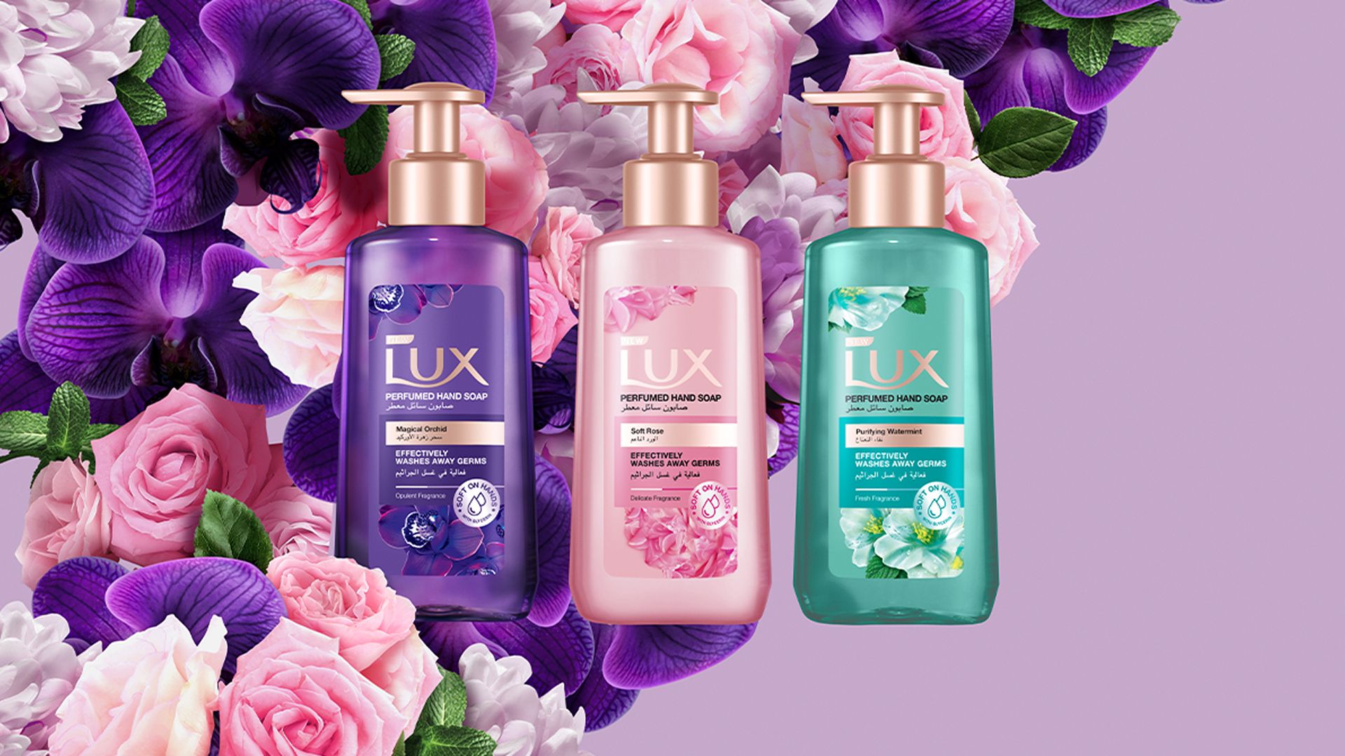 Three Lux perfumed hand soap bottles in purple, pink, and teal displayed against a background of vibrant roses and orchids on a pastel purple backdrop.