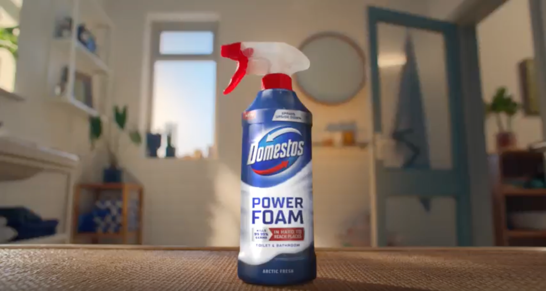 A blue bottle of Domestos power foam on a kitchen counter.
