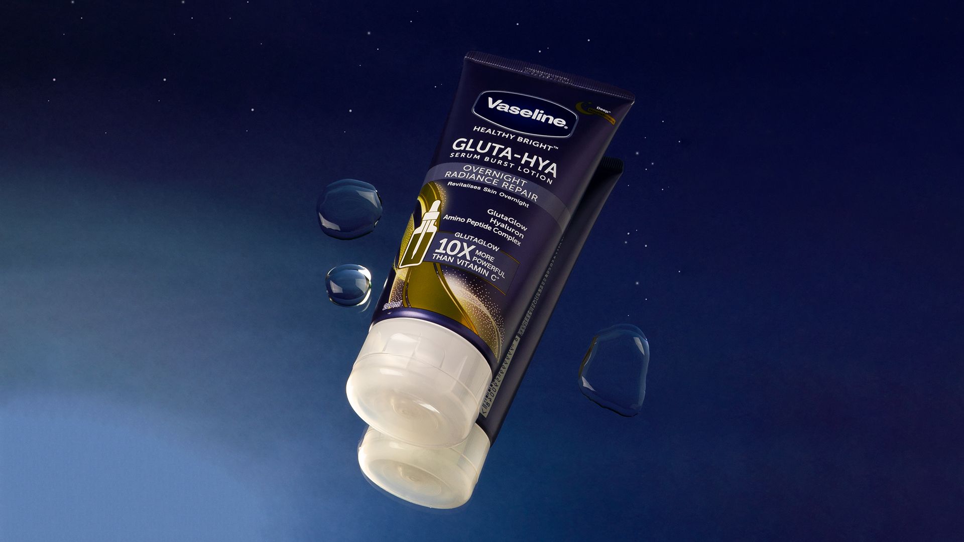 A tube of Vaseline Gluta- Hya Overnight Radiance Repair lotion with a backdrop of a starry night sky. 