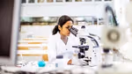 A woman in a laboratory using a microscope